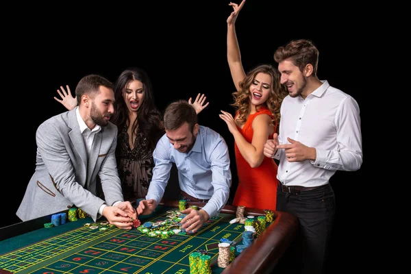 Grupo de adultos celebrando amigo ganar en la ruleta —  Fotos de Stock