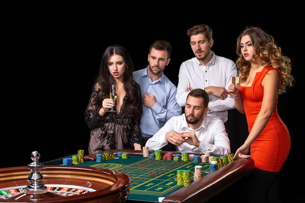 Group of young people looking excited at spinning roulette — Stock Photo, Image