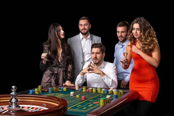 Grupo de jóvenes mirando emocionados en la ruleta giratoria —  Fotos de Stock