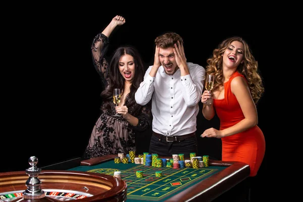 Group of young people looking excited at spinning roulette