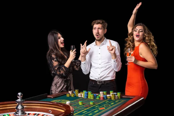 Grupo de jóvenes mirando emocionados en la ruleta giratoria — Foto de Stock