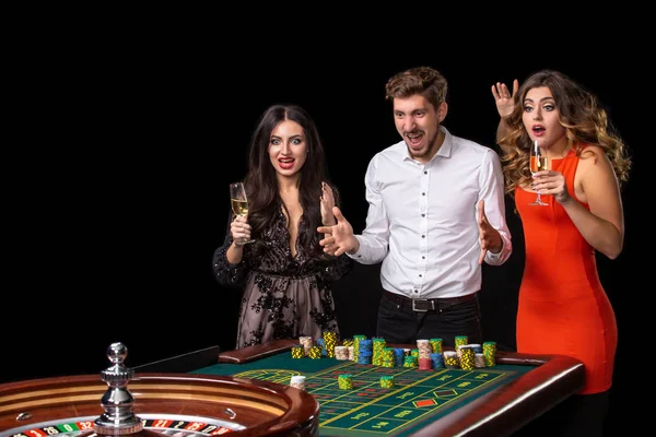 Grupo de jóvenes mirando emocionados en la ruleta giratoria — Foto de Stock