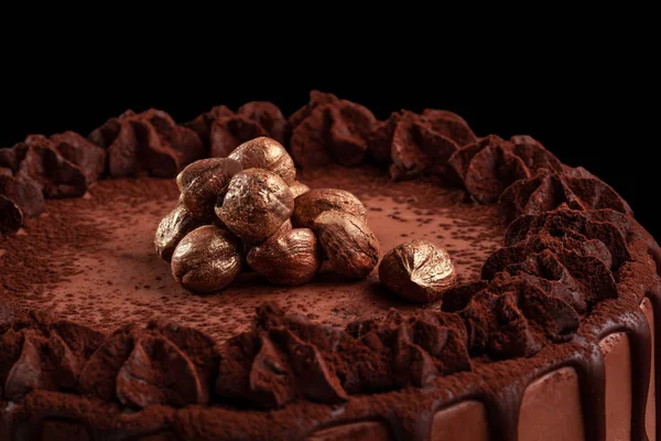 Bolo de chocolate com nozes em um fundo preto. Close-up — Fotografia de Stock