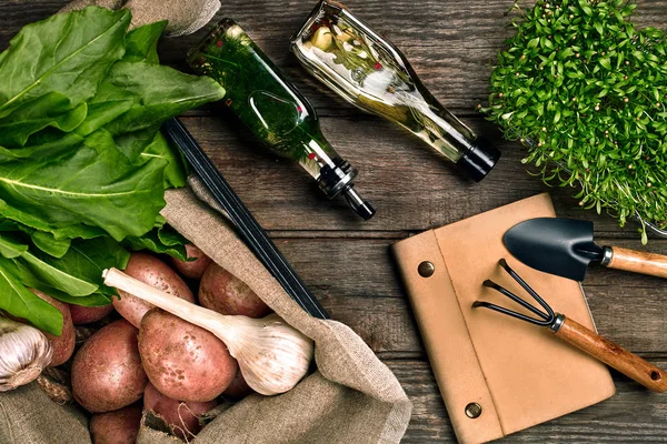 Batatas frescas, óleo, alho e ervas picantes em um fundo de madeira de cozinha. Legumes frescos do seu próprio jardim . — Fotografia de Stock