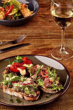 İtalyan sandviç - bruschetta et pate, roka, Güneş ile kurutulmuş domates ve tohum ekmek üzerinde koyu ahşap masa üzerinde.