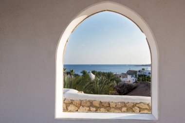 Mısır. Çerçeveyi palmiye ağaçları arasında bir göz. Güzel manzara. Beyaz Saray ve deniz ve palmiye ağaçları bakan veranda.