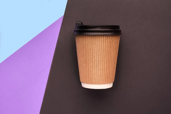 Una taza de café de cartón desechable sobre un fondo colorido — Foto de Stock