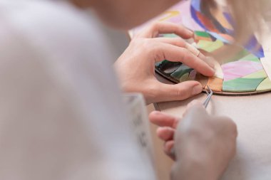 İşyeri mozaik ustası: aracı bir mozaik yapım sürecinde mozaik Ayrıntılar için holding kadın eller