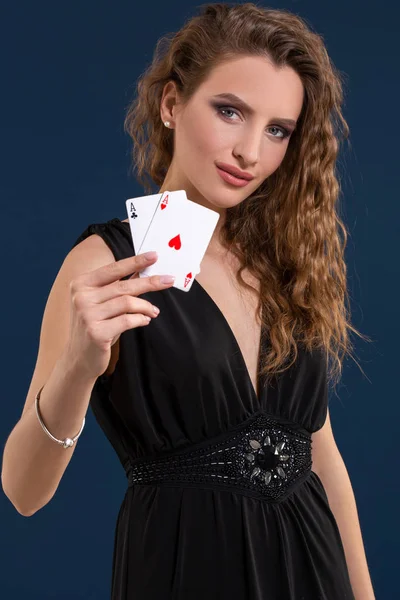 Vacker brunett håller två ess som ett tecken för pokerspel, spel och kasino — Stockfoto