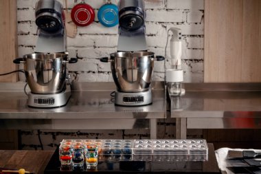 Şekerleme ve ahşap masa üzerinde tatlılar için pişirme araçları. Plastik kalıplar, mikserler, gıda renk, bardak ölçme.