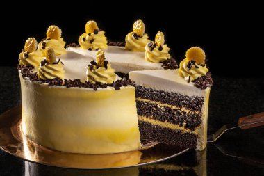 Yuvarlak sarı Doğum günü pastası. Dekoratif kek üzerine krema süslemeleri. Siyah arka plan.