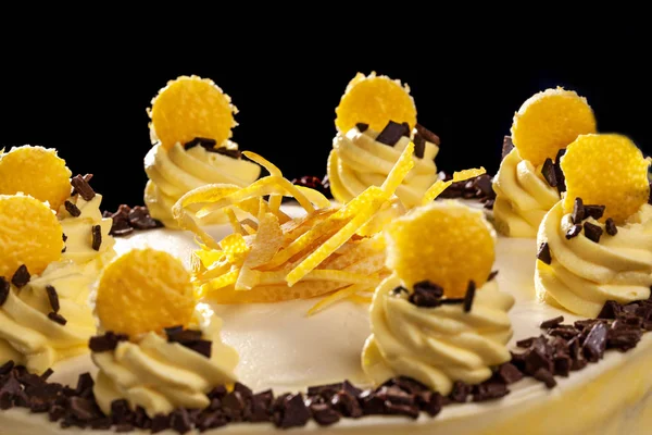 Yuvarlak sarı Doğum günü pastası. Dekoratif kek üzerine krema süslemeleri. Siyah arka plan. Yakın çekim