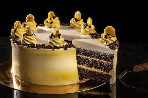 Yuvarlak sarı Doğum günü pastası. Dekoratif kek üzerine krema süslemeleri. Siyah arka plan.