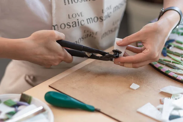 Werkplaats van de meester van de mozaïek: womens handen met hulpmiddel voor Mozaïek details bezig een mozaïek maken — Stockfoto