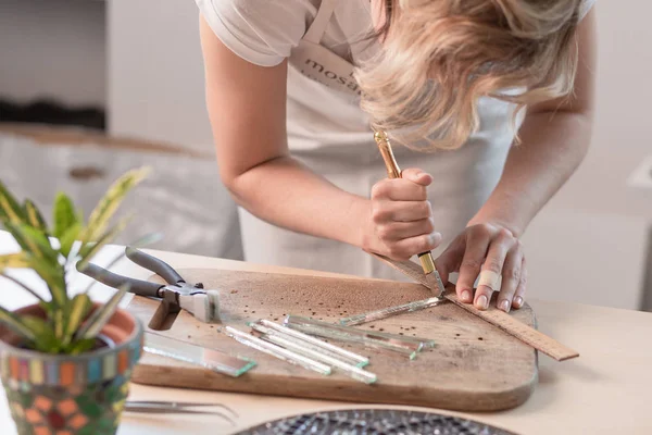 Local de trabalho do mestre do mosaico: mãos das mulheres segurando ferramenta para detalhes do mosaico no processo de fazer um mosaico — Fotografia de Stock
