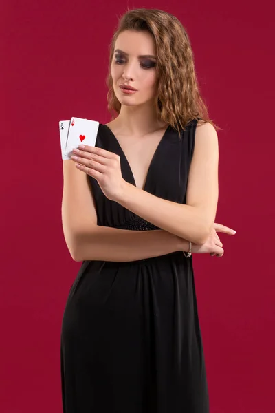 Krásná mladá žena s hrací karty na červeném pozadí — Stock fotografie