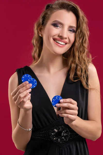 Hermosa mujer con fichas de casino sobre fondo rojo. Retrato — Foto de Stock