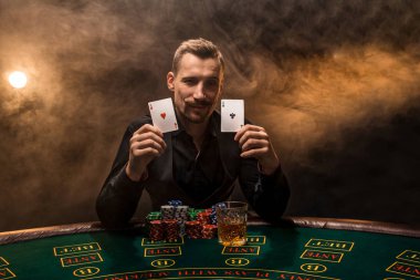 Poker kartları duman siyah arka plan üzerinde gösterilen adam sakallı