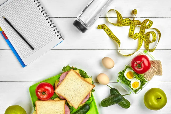 Sağlıklı öğle yemeğinde işyeri veya ev ofisi. Tam tahıllı sandviç jambon ve taze sebze ve şişe suyu. Üstten görünüm, düz ahşap üzerinde yatıyordu