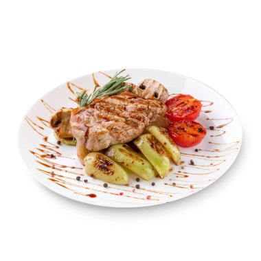 Plaka beyaz zemin üzerine sebzeli ızgara biftek et