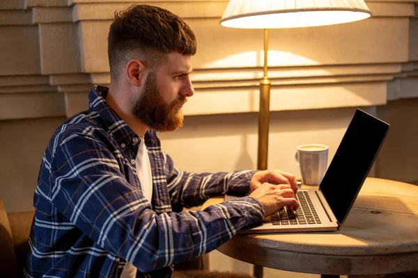 Молодой профессионал серфинга в Интернете на ноутбуке в кафе — стоковое фото