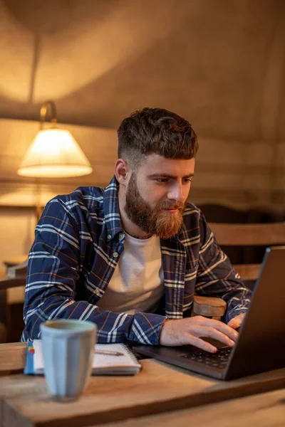Jungprofi surft im Internet auf seinem Laptop in einem Café — Stockfoto