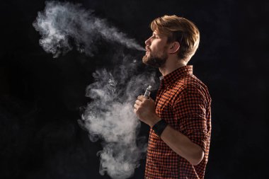 Sakal ve gömlekli, keyfi sigara sigara, bir viper, bir oda, bir stüdyo, duman, şık bir saç modeli olan genç bir adam