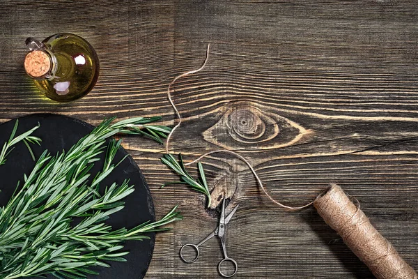 Gri ahşap masa üzerinde biberiye dalı. Biberiye kesme tahtası üzerinde. Rustik tarzı, taze organik otlar.