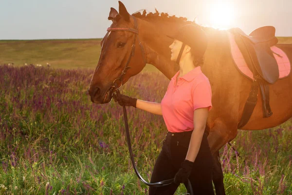 Beautiful young girl smile at her horse dressing uniform competition: outdoors portrait on sunset. Sun flare — Stock Photo, Image