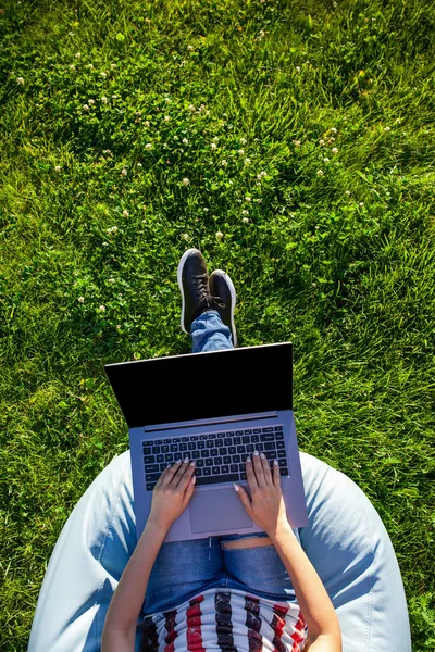 Ovanifrån. Kvinna som arbetar på bärbar pc dator med blank svart tom skärm att kopiera utrymme i parken på grönt gräs sunshine gräsmatta utomhus. — Stockfoto