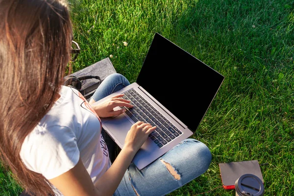 Fermez les mains sur le clavier. Femme travaillant sur ordinateur portable PC avec écran vide noir vierge pour copier l'espace dans le parc sur gazon vert pelouse ensoleillée à l'extérieur . — Photo