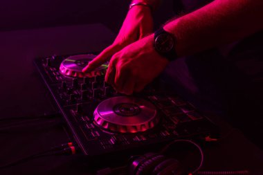 Dj turntable üzerinde renk ışık efektleri ile karıştırma. El yumuşak odak. Yakın çekim.