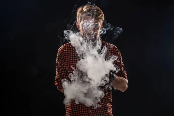 Mladý muž s plnovousem a stylový účes v košili, kouření cigaret, viper, pokoj, studio, kouř, potěšení — Stock fotografie