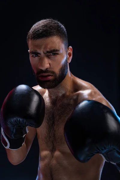 Retrato de boxeador masculino duro posando em postura de boxe contra fundo preto . — Fotografia de Stock