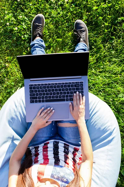 Ovanifrån. Kvinna som arbetar på bärbar pc dator med blank svart tom skärm att kopiera utrymme i parken på grönt gräs sunshine gräsmatta utomhus. — Stockfoto