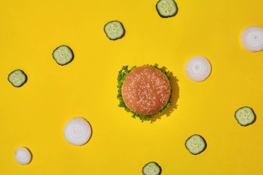 Ketçap ve sarı canlı parlak arka plan üzerinde sebze ile lezzetli taze sağlıksız hamburger. Kopya alanı ile üstten görünüm.