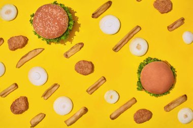 En popüler fast food yemek. Tavuk nuggets, hamburger ve patates kızartması üzerinde sarı arka plan üstten görünüm