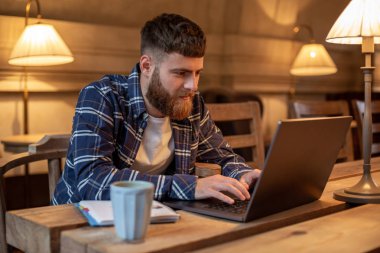 Genç profesyonel bir kafede onun Laptop Internet sörf