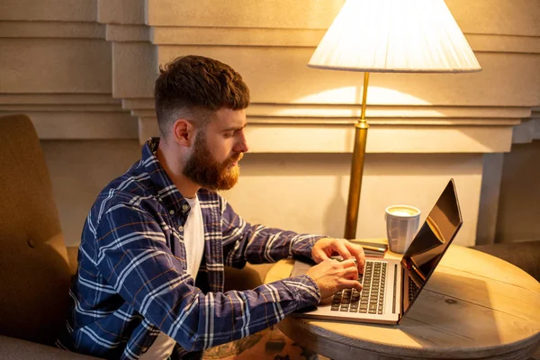 Jungprofi surft im Internet auf seinem Laptop in einem Café — Stockfoto