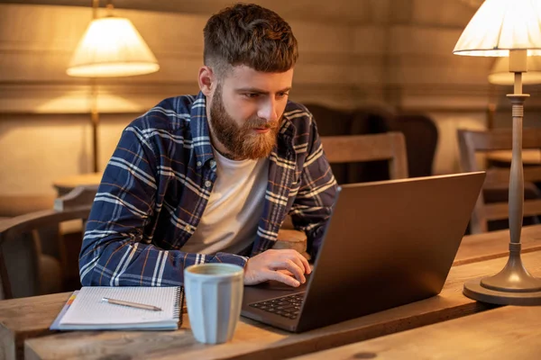 Joven profesional navegando por Internet en su portátil en un café — Foto de Stock