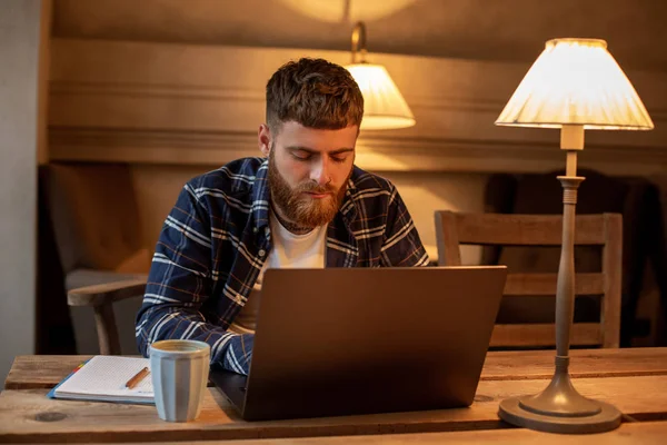 Jungprofi surft im Internet auf seinem Laptop in einem Café — Stockfoto