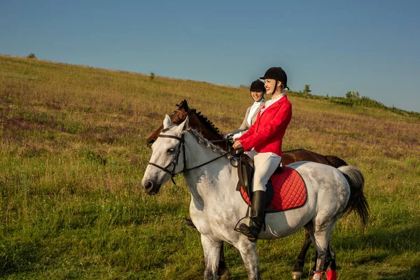 Two young women riding horse in park. Horse walk in summer — Stock Photo, Image