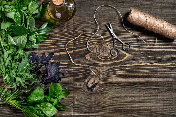 Ahşap arka plan üzerinde taze organik otlar çeşitli. Taze fesleğen, dahil olmak üzere otlar hasat roka. Üstten görünüm. Kopya alanı.