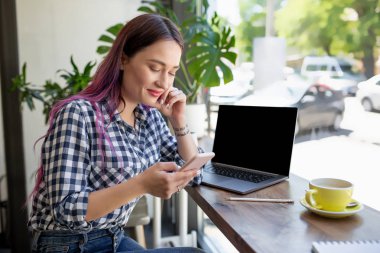 Kadın defter ile kopya alanı metin veya reklam içeriği, tahta masada oturan için boş ekran ile yazarak