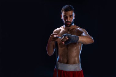 Spor boxer erkek el bilek tamamladı çeker. Siyah arka plan üzerine izole oryantal erkek modeli.