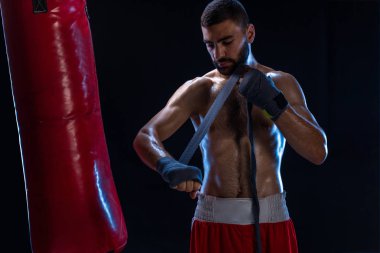 Spor boxer erkek el bilek tamamladı çeker. Siyah arka plan üzerine izole oryantal erkek modeli.
