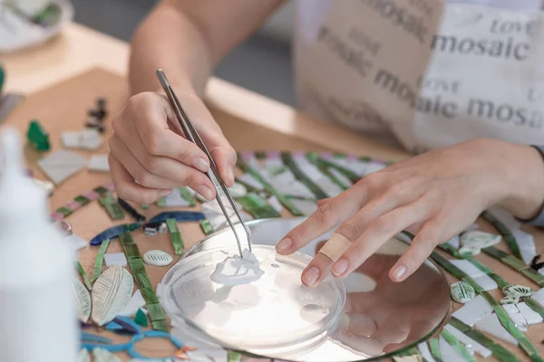 Handen van master bezig met nieuwe moderne kleurrijke mozaïek. Close-up — Stockfoto