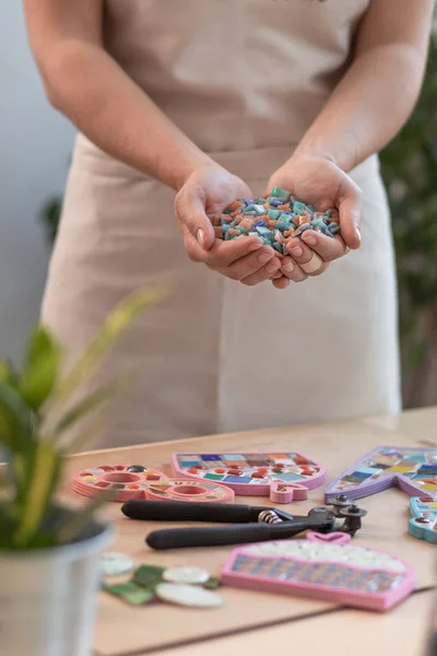 Local de trabalho do mestre do mosaico: mãos das mulheres segurando detalhes em mosaico no processo de fazer um mosaico — Fotografia de Stock