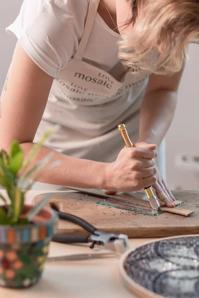 Kunstenaar snijden vellen gekleurd glas in kleine mozaïek vierkanten. Close-up — Stockfoto