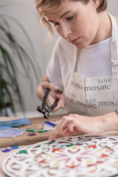 Lieu de travail du maître de la mosaïque : les mains des femmes tenant l'outil pour les détails de la mosaïque dans le processus de fabrication d'une mosaïque — Photo